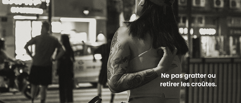Femme qui se gratte Une femme qui se gratte le dos afin d'imager qu'il ne faut pas gratter ou retirer les croûtes du tatouage